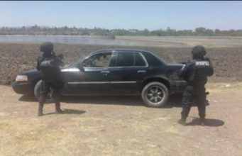 Abandonan Grand Marquis con arma y droga en su interior